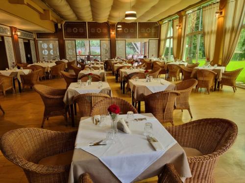 丹吉尔El Oumnia Puerto & Spa的餐厅配有桌椅和白色桌布