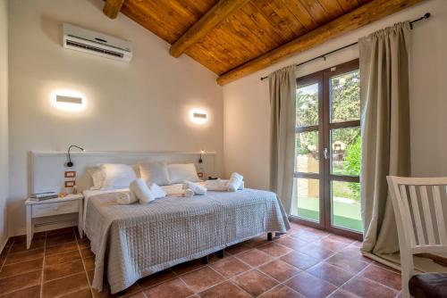 阿尔盖罗Alghero Resort Country Hotel & Spa的一间卧室设有一张床和一个大窗户