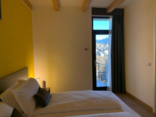 松德里奥Guest House Le Cassandre的一间卧室设有一张床和一个大窗户