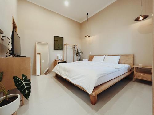 Bien HoXOM House Biển Hồ的一间卧室配有一张床和一台电视