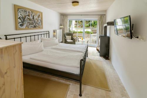 奥斯特西巴德钦诺维茨Usedom Refugium的一间卧室配有一张带白色床单的床和电视。