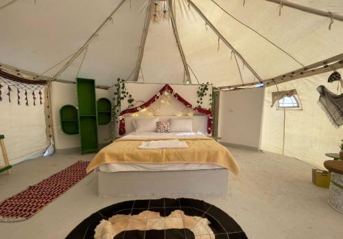 Qasr Al FarafirahShahrazad Camp in white desert, Egypt的帐篷内一间卧室,配有一张床