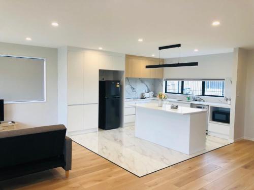 奥克兰Modern & Luxurious Home 2的厨房配有白色的柜台和黑色的冰箱。