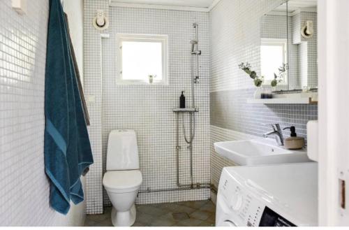韦姆德Cosy house in the archipelago的白色的浴室设有卫生间和水槽。