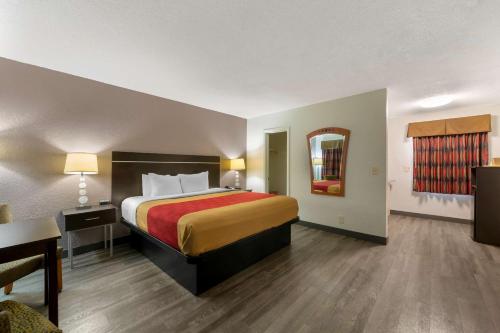 好莱坞Econo Lodge Hollywood - Ft Lauderdale International Airport的酒店客房设有一张大床和一张桌子。