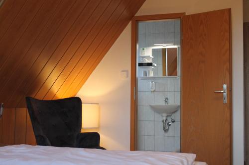 迈宁根Träbeser Bauernstube的一间卧室配有一张床、一个水槽和一把椅子