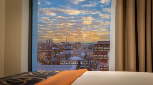 格拉斯哥Clayton Hotel Glasgow City的卧室窗户享有城市美景。
