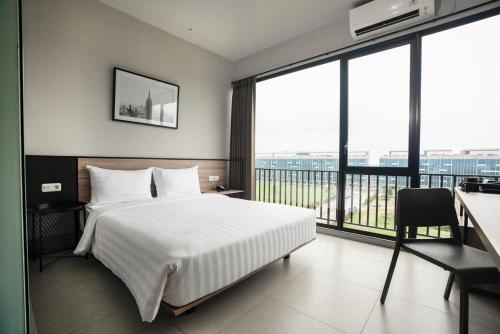 当格浪CONJIOO HOTEL at JAKARTA AIRPORT的酒店客房设有一张床和一个大窗户