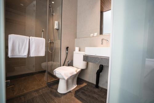 当格浪CONJIOO HOTEL at JAKARTA AIRPORT的浴室配有卫生间、盥洗盆和淋浴。