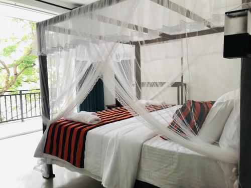 韦利格默River Post Coworking and Coliving Weligama的一间卧室配有一张带蚊帐的床