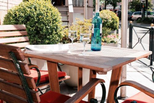 汉堡贝斯特韦斯特酒店圣·拉斐尔店的一张木桌,配有两杯酒杯和一瓶