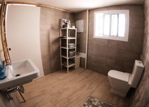 大加那利岛拉斯帕尔马斯La casa de la playa的一间带水槽和卫生间的浴室以及窗户。