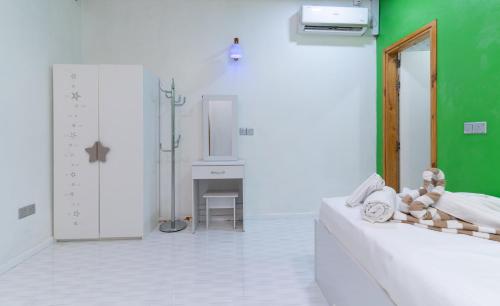乌库拉斯Maafolhey Han'dhaan - Ukulhas的白色的浴室设有绿色的墙壁和水槽