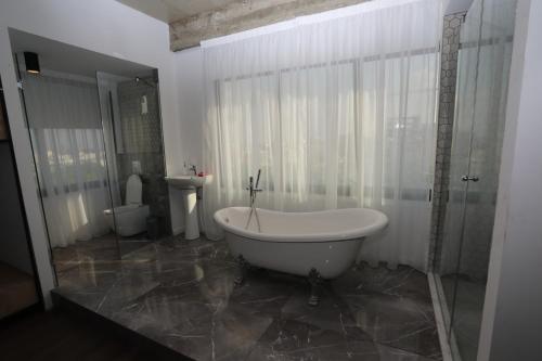 尼科西亚GR市中心公寓的带浴缸、卫生间和盥洗盆的浴室