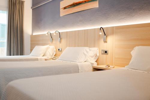 马翁欧洲酒店的酒店客房,配有两张带白色床单的床