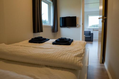 SmølaVollvaagen Apartments Smøla, boat included的一间卧室配有一张带两张黑色毛巾的床