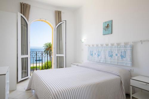 圣安蒂奥科MuMA Hostel的一间白色的卧室,配有一张床,享有海景