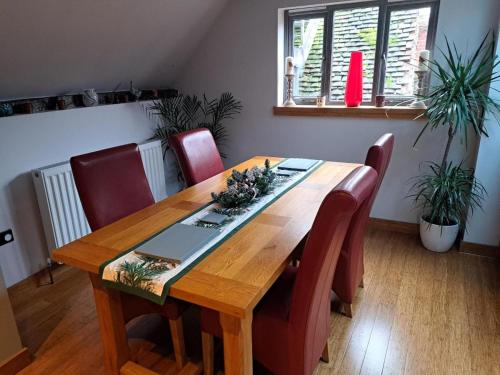布由德利Riverside 2 bed apartment Bewdley Worcestershire的一张带红色椅子和木桌的餐桌