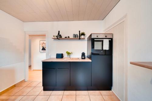 斯图加特Stuttgart am Wasen Toplage 4Zi 80qm的厨房配有黑色冰箱和台面