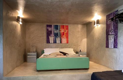 圣维托罗卡波Villa Il Cappero的卧室配有一张床,墙上挂有两幅画