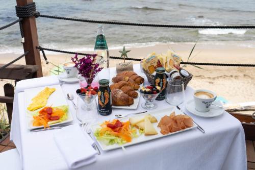 瓦雷多利亚La Locanda del Mare的海滩上一张带食物盘的桌子