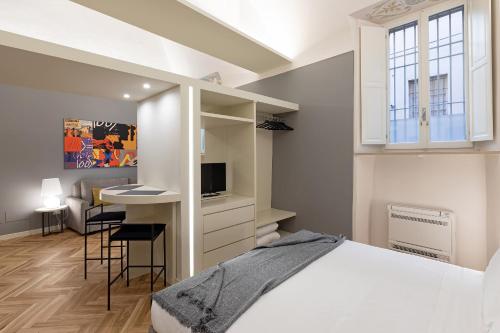 帕尔马Palazzo Liberati Apartments的一间卧室配有一张床和一张书桌及电视