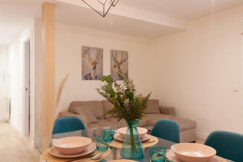 阿维拉Apartamento Premium PLAZA MAYOR con PARKING的客厅配有玻璃桌和蓝色椅子