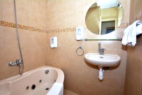 Kramim甘哈克拉米姆乡村住宿酒店的一间带水槽、浴缸和镜子的浴室