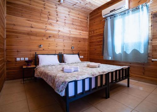Kramim甘哈克拉米姆乡村住宿酒店的卧室配有木墙内的一张床