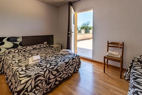 LlambillasCan Bugantó amplia casa con piscina y jardín的卧室配有床、椅子和窗户。