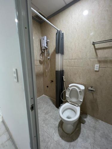 Bùi TiếngHello Hotel的一间带卫生间的浴室和墙上的一部电话