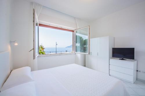 马奥莱马约里假日公寓的白色的卧室设有床和窗户