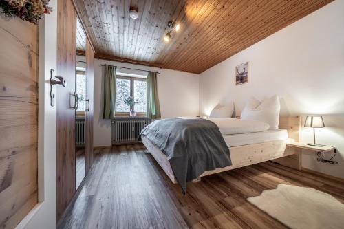 伦格里斯Haus Hohenwiesen的一间卧室设有一张床和木制天花板