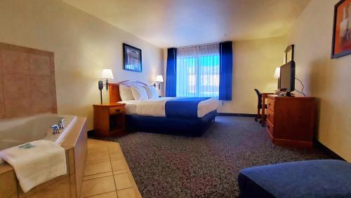 马尼温泉Magnuson Grand Pikes Peak的酒店客房设有一间带一张床和浴缸的卧室