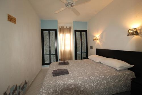卡勒达德福斯特Casa Maria N2 Montecastillo的一间卧室配有一张带风扇的床和两个窗户。