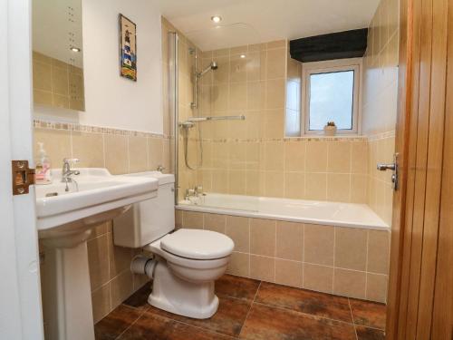 林顿Potters Cottage的浴室配有卫生间、盥洗盆和浴缸。