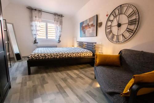奥贝奈Le nid cosy d'Obernai /2min centre ville/parking的卧室配有一张床,墙上挂着一个钟