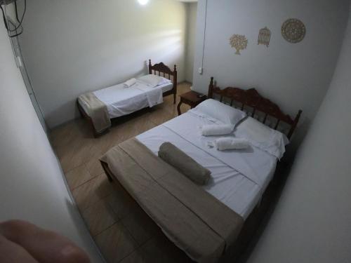 PedreiraPousada Solar da Montanha的一间卧室配有两张带白色床单的床