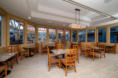 托皮卡Endeavor Inn & Suites, Trademark Collection by Wyndham的餐厅设有桌椅和窗户。