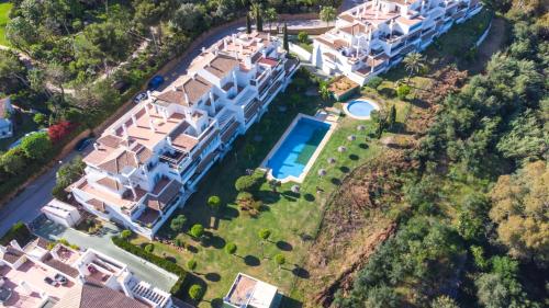 马贝拉Ático familiar con terraza y bonitas vistas al mar en Marbella - Rio Real 282G的享有带游泳池的大房子的空中景致