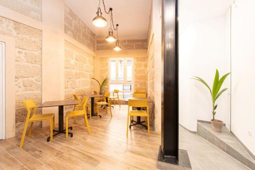 阿德耶Hotel Adeje Plaza的用餐室配有桌子和黄色椅子