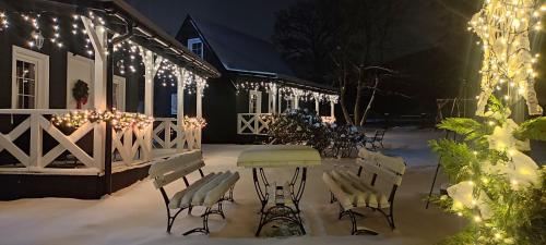 米尔科Domek pod Karpaczem的庭院在晚上的雪中摆放着桌椅