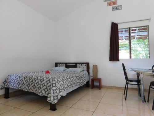 萨玛拉Villasjungle 1的一间卧室配有一张床、一张桌子和一个窗户。