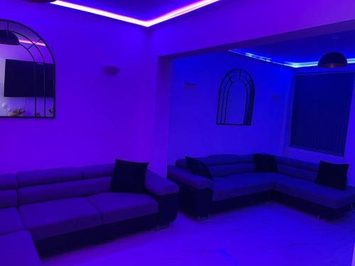 曼彻斯特Short Stopzzz & Indoor Hot Tub的客厅配有紫色灯和沙发