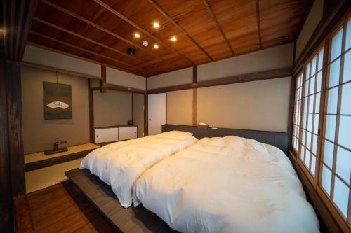 TakahashiCastle Town Contemporary Ryokan 天籟 - TENRAI -的窗户客房内的一张大白色床