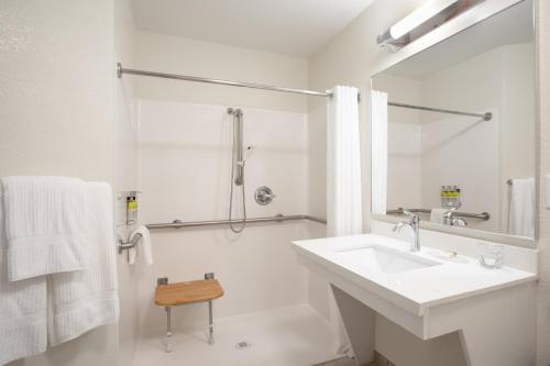 夏延夏延烛木套房酒店的白色的浴室设有水槽和淋浴。