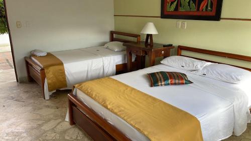 Puerto BerríoHotel Tayrona的酒店客房,设有两张床和一盏灯