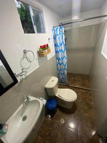 PapagallerosFinca Villa Maju的浴室配有卫生间、浴缸和水槽。