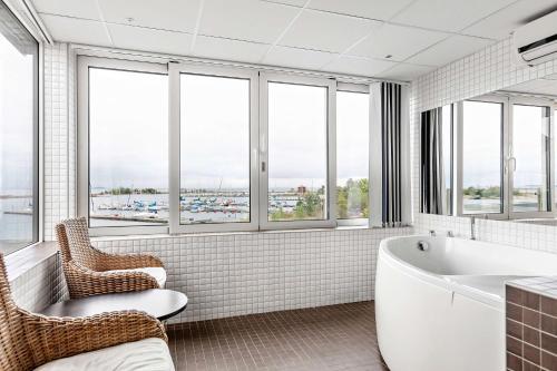 奥斯卡港科拉勒贝斯特韦斯特酒店的带浴缸、椅子和窗户的浴室
