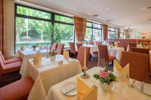 汉堡贝斯维斯特汉堡国际酒店的餐厅设有白色的桌椅和大窗户。